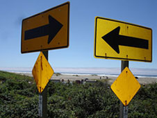Twee verkeersborden die naar
  elkaar wijzen
